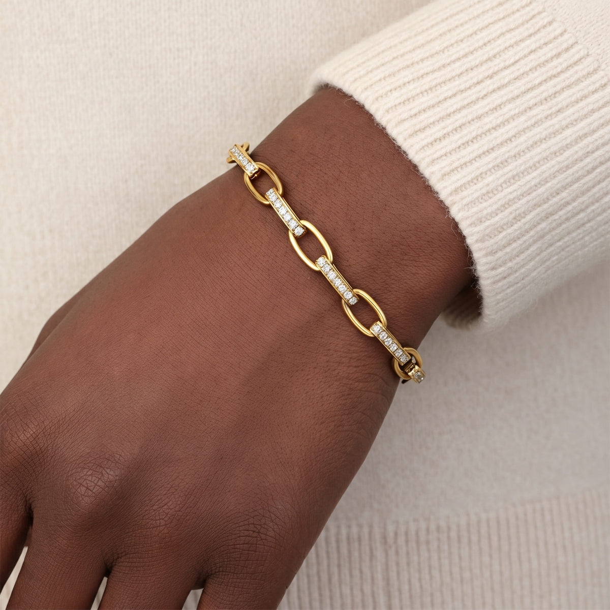 Bracelet Maillons Lumière doré porté avec un pull crème, Sway